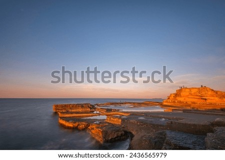 unique shaped cliffs blue sea and cloudy sky at sunset
