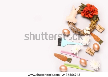 Composition with hairdresser's supplies, Easter eggs and decor on light background