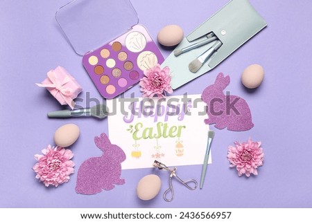 Composition with greeting card, makeup accessories, eyeshadows and Easter decor on lilac background