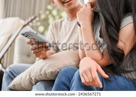 A cropped shot of a happy young Asian couple talking while relaxing on a sofa in the living room. boyfriend and girlfriend concept Royalty-Free Stock Photo #2436567271