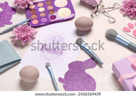 Composition with greeting card, makeup accessories, cosmetics and Easter decor on light background