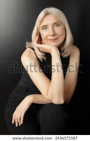 beautiful blond woman in her 50 plus posing on black background