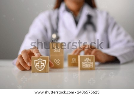 Doctor's hand touching wooden cubes with medical icon. Health Insurance concept