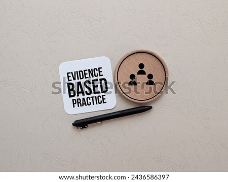 Evidence Based Practice text written on paper, pen with people icon on round piece of wood.