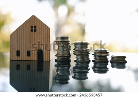 close up stack of coin and toy house on table, saving and manage money for building, home insurance business technology, subprime mortgage crisis risk and problem concept