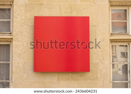 Blank red billboard sign mockup in the urban environment. Clear urban glued advertising canvas. Billboard advertisement advertiser on the wall