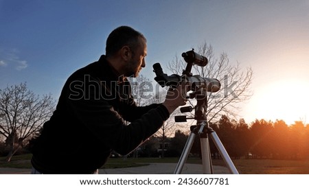 Amateur astronomer observing Sun eclipse and Sun with a telescope and special solar filter. Royalty-Free Stock Photo #2436607781