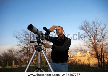 Amateur astronomer observing Sun eclipse and Sun with a telescope and special solar filter. Royalty-Free Stock Photo #2436607787