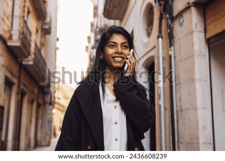 young woman walking through the city using a device 