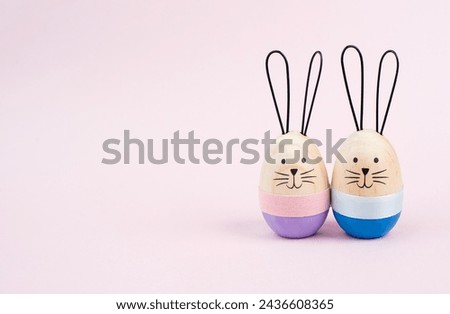 Easter bunny or rabbit couple cuddle together, wooden egg, spring holiday greeting card 