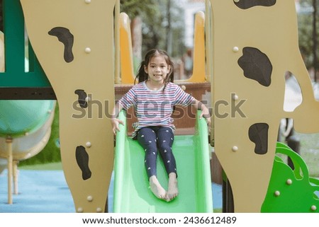 Little girl having fun on the playground in the park, outdoor sh