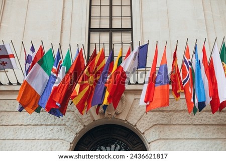 National flags of various countries flying in the wind. Colorful flags from different countries. Flags Organization for Security and Co-operation in Europe Royalty-Free Stock Photo #2436621817