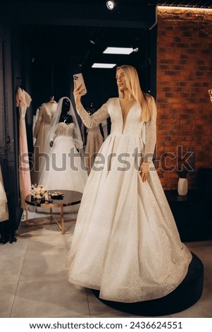 the bride takes a picture of herself in the mirror in the wedding salon