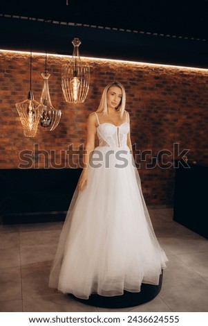 Beautiful young blonde woman standing Choosing a wedding dress. High quality photo