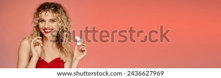 joyful curly woman with red lips and radiant smile holding dental floss on gradient backdrop, banner