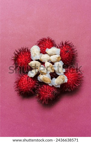 Rambutan fruit seeds on a red background. Rambutan is a tropical fruit.