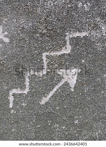 Stairs symbol and arrow pointing up on cement wall.