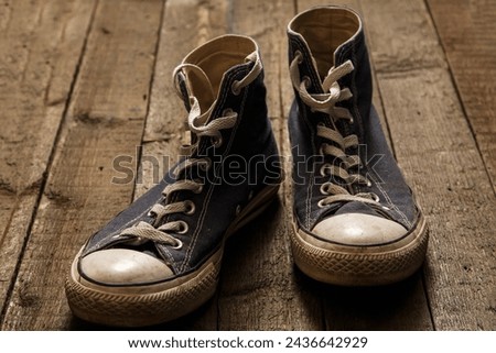 Dirty gumshoes on wooden background Royalty-Free Stock Photo #2436642929