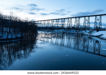 Blue hour view of the 1908 railway trestle bridge over the Cap-Rouge River seen during a winter sunrise, Cap-Rouge area, Quebec City, Quebec, Canada Royalty-Free Stock Photo #2436644525