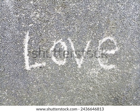 The word love on a cement wall.