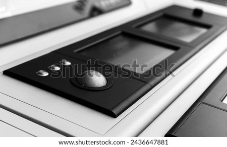 Built-in tabletop input device with trackball mouse and digital touch screens. Black and white photo with selective focus Royalty-Free Stock Photo #2436647881