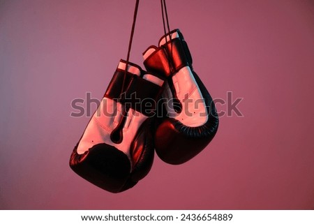 Boxing gloves are illuminated with red light