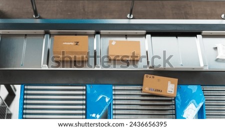 Autonomous Conveyor Belt Sorting Mechanism with Artificial Intelligence Capabilities Handling, Sorting and Preparing Parcels for Delivery to Online Clients in a Modern Logistics Warehouse Royalty-Free Stock Photo #2436656395
