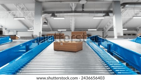 Recyclable Cardboard Box Being Transported on a Conveyor Belt in a Modern Logistics Center. Parcel is Prepared for Delivery to an Online Client. Rendered Conveyor System of a Big Retail Business Royalty-Free Stock Photo #2436656403