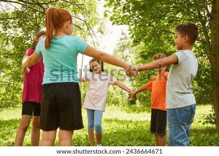 Friends holding hands while playing ring-around-the-rosy at park Royalty-Free Stock Photo #2436664671