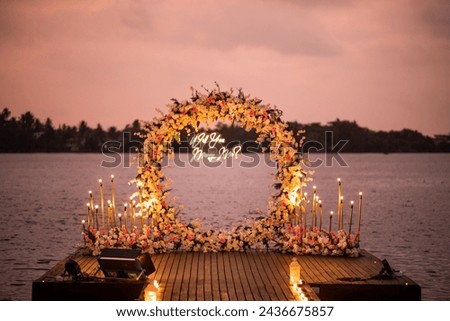 Close portrait look of will you marry me lights on a riverside pathway with flower decorations 