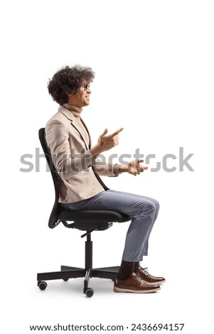 Profile shot of a man sitting in an office chair and explaining with hands isolated on white background