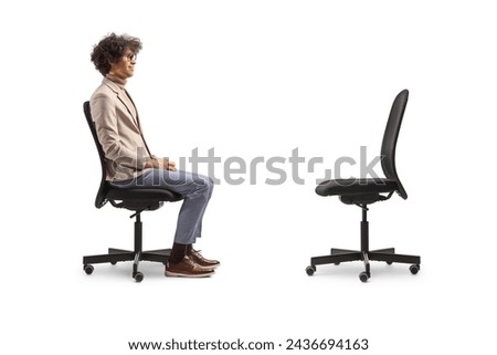 Profile shot of a man sitting in an office chair and looking at an empty chair isolated on white background