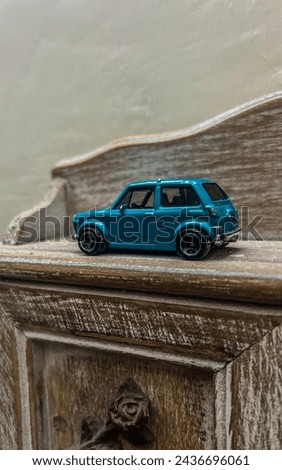 Toy Car used as decoration. Cyan color car placed on a wooden frame. Antique piece car