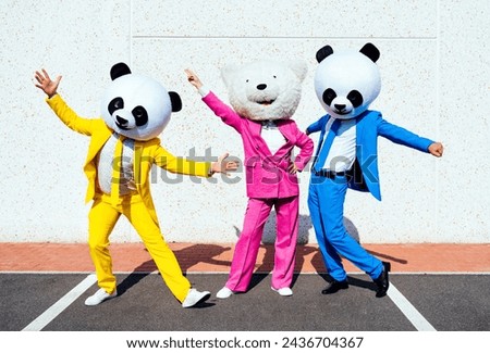 Storytelling image of a couple wearing giant panda head and colored suits. Man and woman making party in a parking lot. Royalty-Free Stock Photo #2436704367