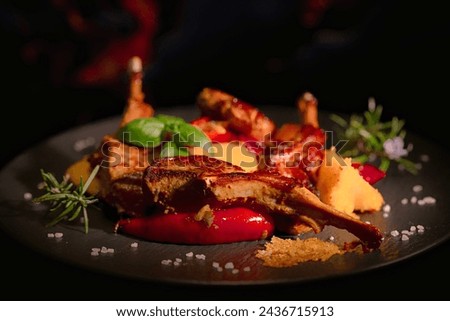 On a black porcelain plate, rack of lamb with fried polenta and hot peppers. Restaurant menu. Homemade food. Very beautiful and appetizing. Royalty-Free Stock Photo #2436715913