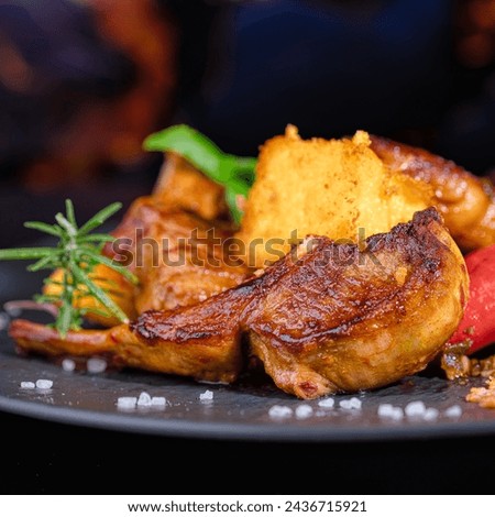 On a black porcelain plate, rack of lamb with fried polenta and hot peppers. Restaurant menu. Homemade food. Very beautiful and appetizing. Royalty-Free Stock Photo #2436715921