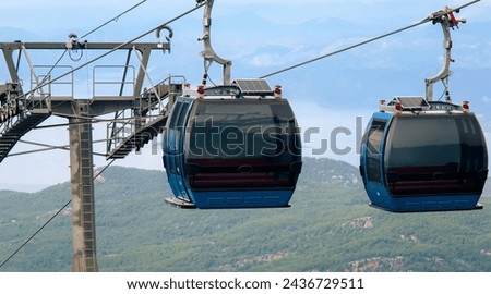 Ropeway, cable car cabins against seascape in Oludeniz, Turkey. Tourism, cableway, sightseeing concept. Cableway system at Babadag Peak. High quality photo Royalty-Free Stock Photo #2436729511