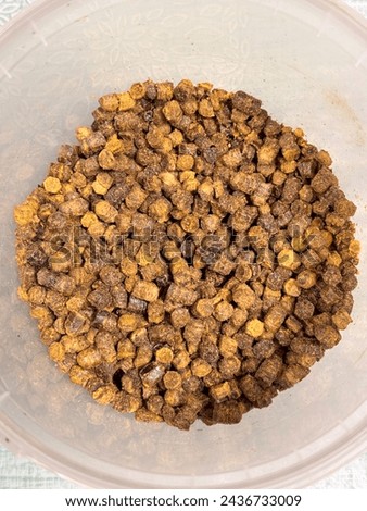 A lot of bee perga, ambrosia, bee pollen in a plastic container. Top view. Close up.