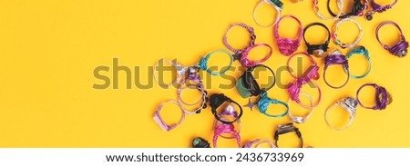 Banner with handmade rings made of wire and natural stones on a yellow background. 