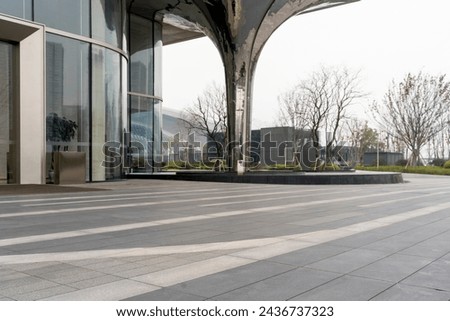empty concrete floor in front of modern buildings in the downtown street. copy space for parking lot. Royalty-Free Stock Photo #2436737323