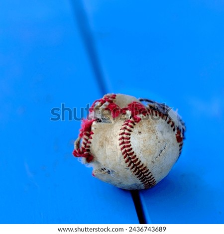 Closeup detail of old worn ragged baseball with torn cover and seams for sports