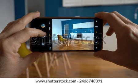 Real estate photographer taking pictures and videos  at house  in apartment living room with mobile phone  - selling home with real estate agency and home staging indoor home design 