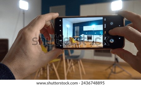 Real estate photographer taking pictures and videos  at house  in apartment living room with mobile phone  - selling home with real estate agency and home staging indoor home design - vertical photo