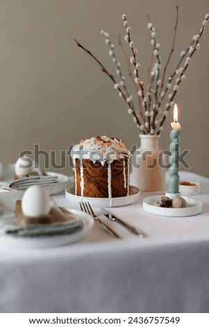 Happy Easter! Easter festive spring table setting decoration, eggs, Easter cake, willow branches in vase. Easter family dinner or breakfast concept Royalty-Free Stock Photo #2436757549