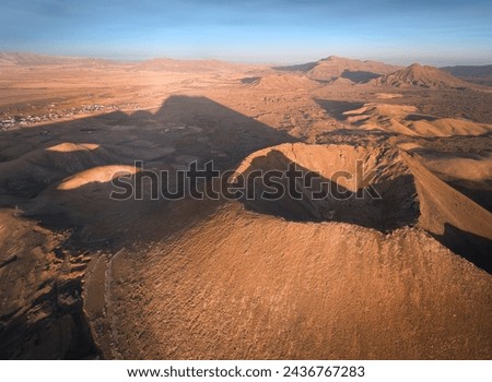 Gairia Volcano in central Fuerteventura, panoramic aerial view of the volcano and volcanic structures in the vicinity during sunset. A place for a hike. Canary Islands.   Royalty-Free Stock Photo #2436767283