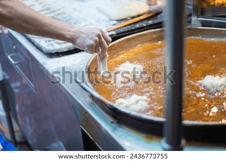 Picture of the process of making food from carbohydrate flour ingredients and frying them in hot oil.