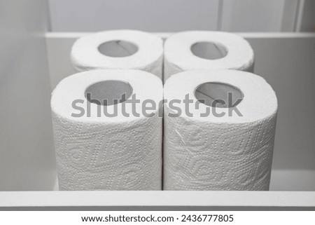 several rolls of paper towel lie in the kitchen cabinet. paper towel in the closet. High quality photo