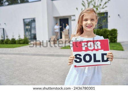 Girl in white dress stands with signs for sale, sold