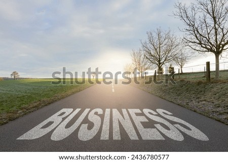 Asphalt road with arrow guideline and Business letters painted on the surface. An image of a road milestones are representative of success in the future goal. Road to success with light of the sun. Royalty-Free Stock Photo #2436780577