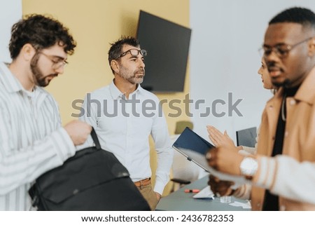 Diverse colleagues analyze statistics, discuss projects, and strategize for business growth in a cozy workplace. Royalty-Free Stock Photo #2436782353